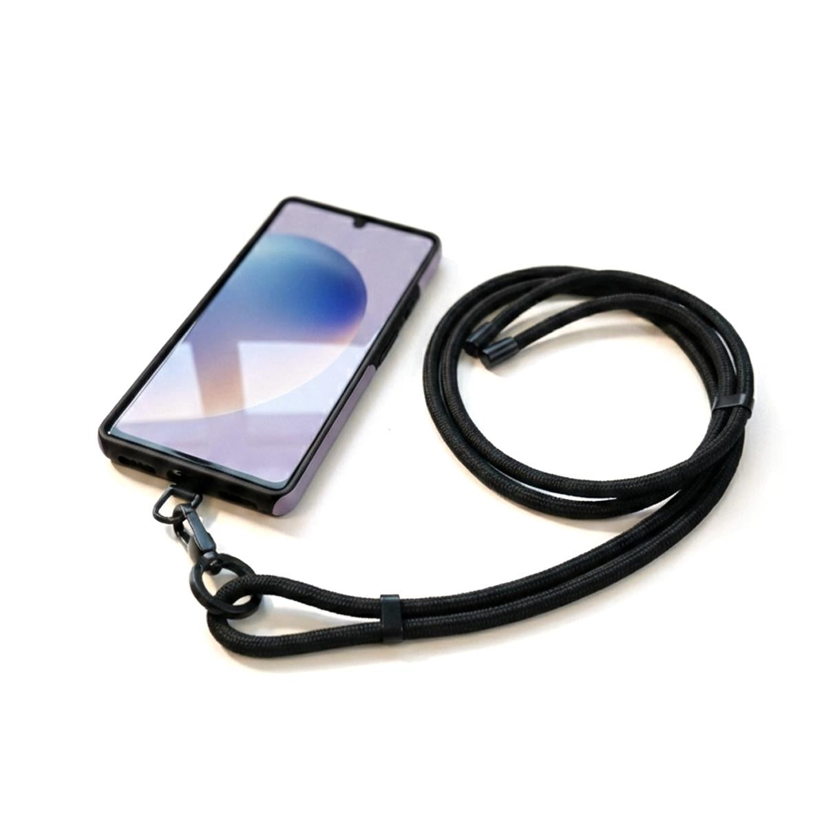 Smartphone mit einer langen, schwarz gewickelten Handykette, die durch ein Einlege-Patch an der Hülle fixiert ist.