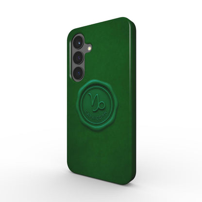 Tannengruene Tough Handyhuelle mit gepraegtem Capricorn-Siegel, schraeg von hinten; Dual-Layer PC+TPU, raised bezel.